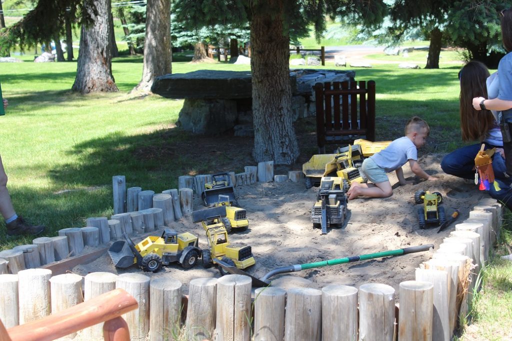 Youngsters excavating for dinosaurs in sandbox at Flathead Lake Lodge